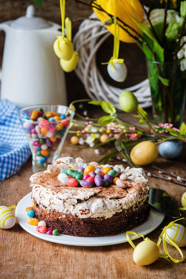 Osterkuchen mit Schokolade, Baiser und bunten Zuckereiern