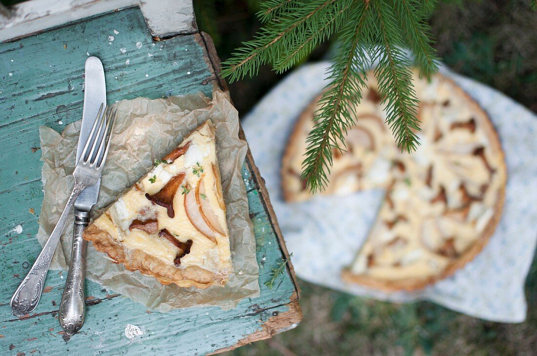 Ein Stück Quiche mit Waldpilzen, Birnen und Ziegenkäse