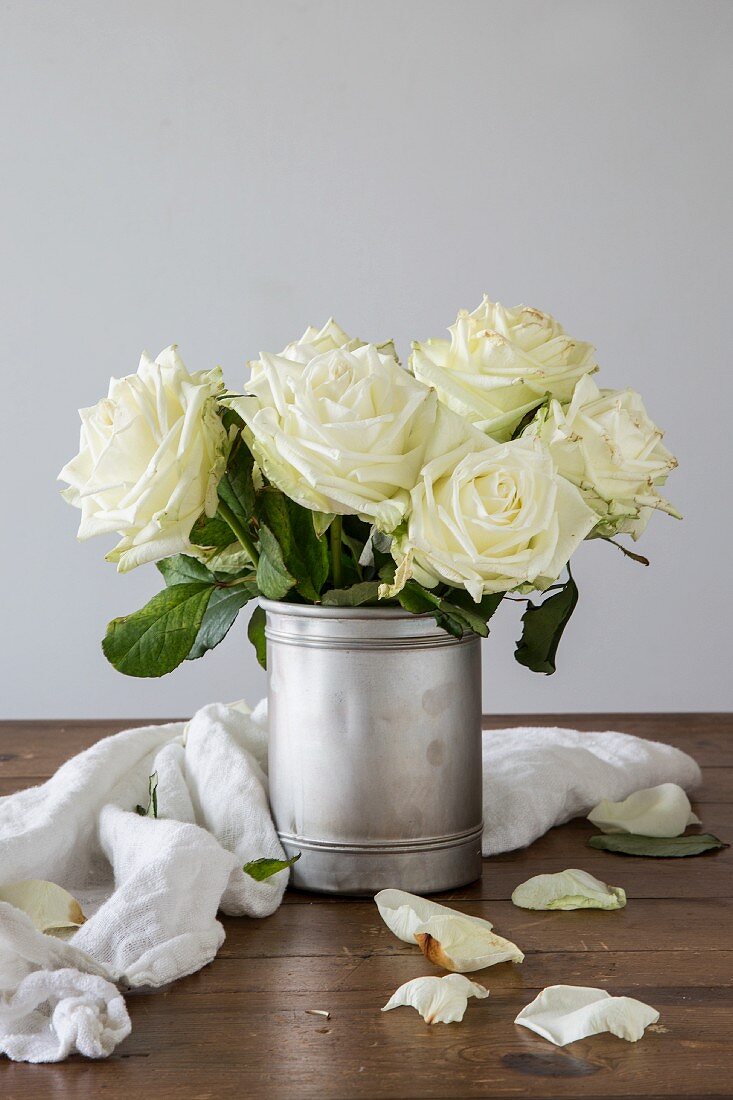 Posy of white roses in old silver pot