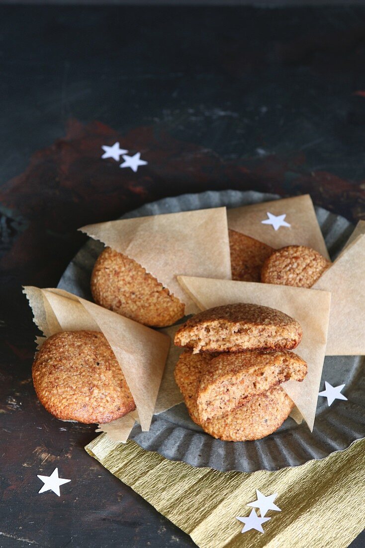 Homemade gingerbread in parchment pockets on a pewter plate, scattered with stars (gluten-free)
