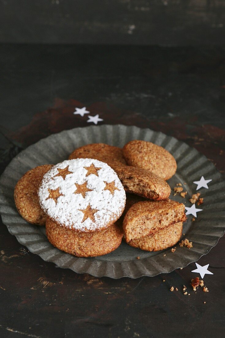 Glutenfreie selbstgemachte Lebkuchen mit Sternen und Puderzucker auf Zinnteller