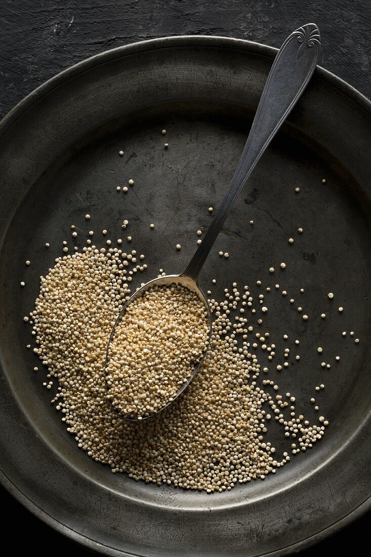 Quinoa with a spoon on an old metal plate