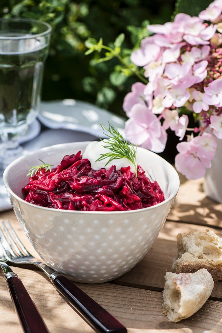 Rote-Bete-Orzotto im Schälchen auf Tisch im Freien