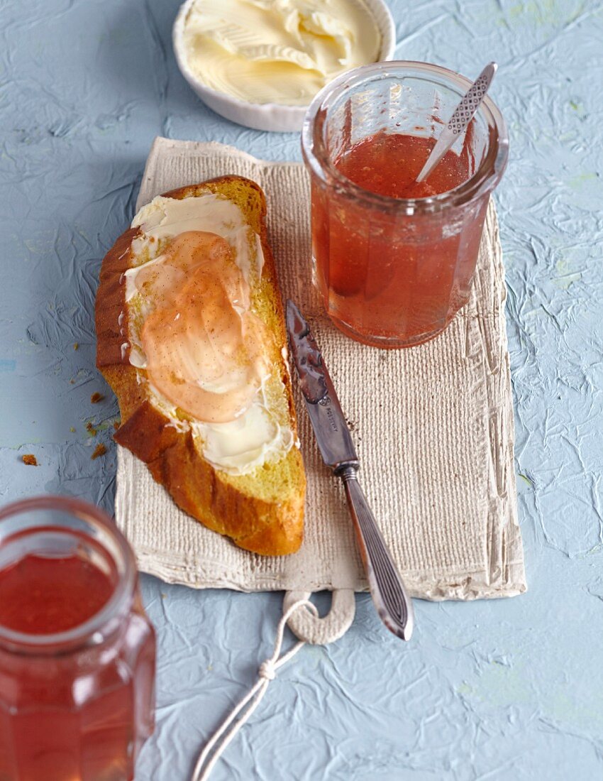 Quince jelly in a glass jar and spread on a slice of bread