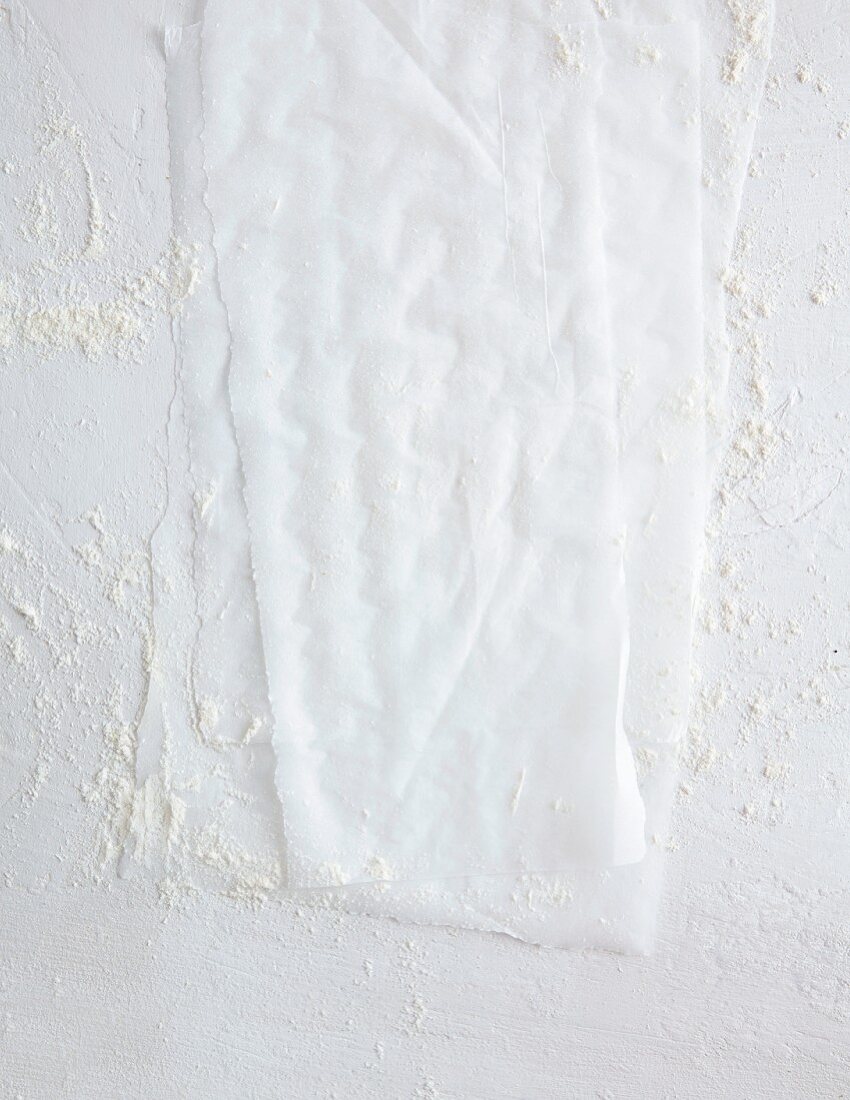 Backpapier auf weißem Untergrund mit Mehl