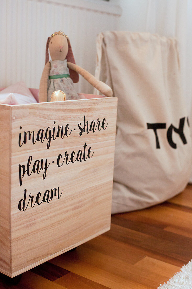 Wooden toy chest with motto made from stickers