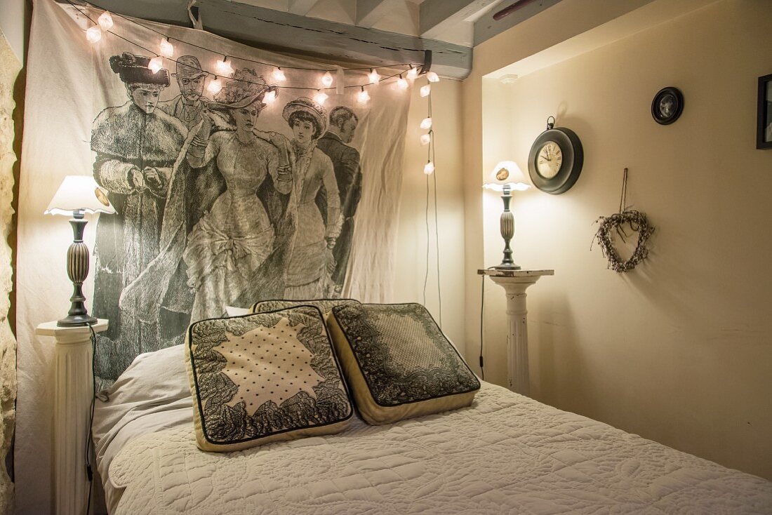 Fairy lights, antique bedside lamps and wall hanging in vintage bedroom