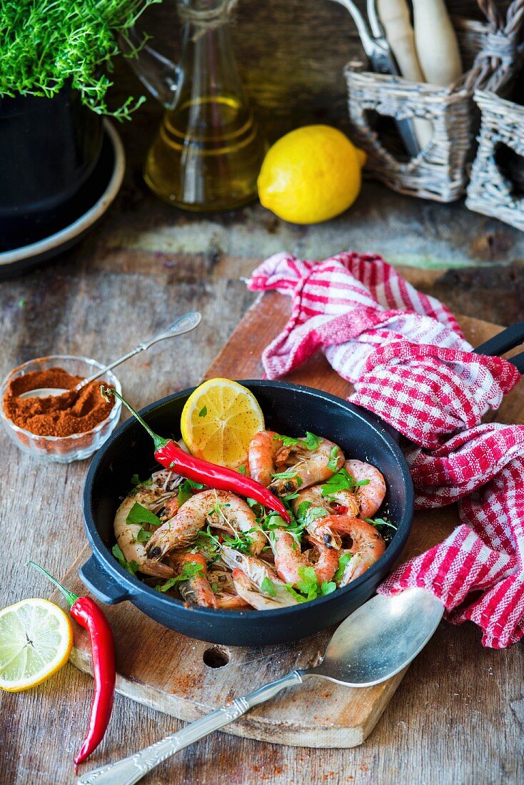 Fried spicy prawns with herbs in a pan