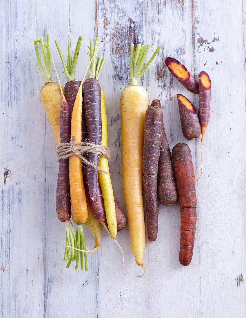 Colourful carrots on a white wooden background