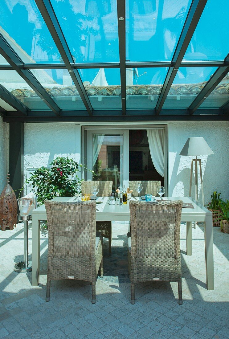 Set table and wicker chairs in Mediterranean conservatory