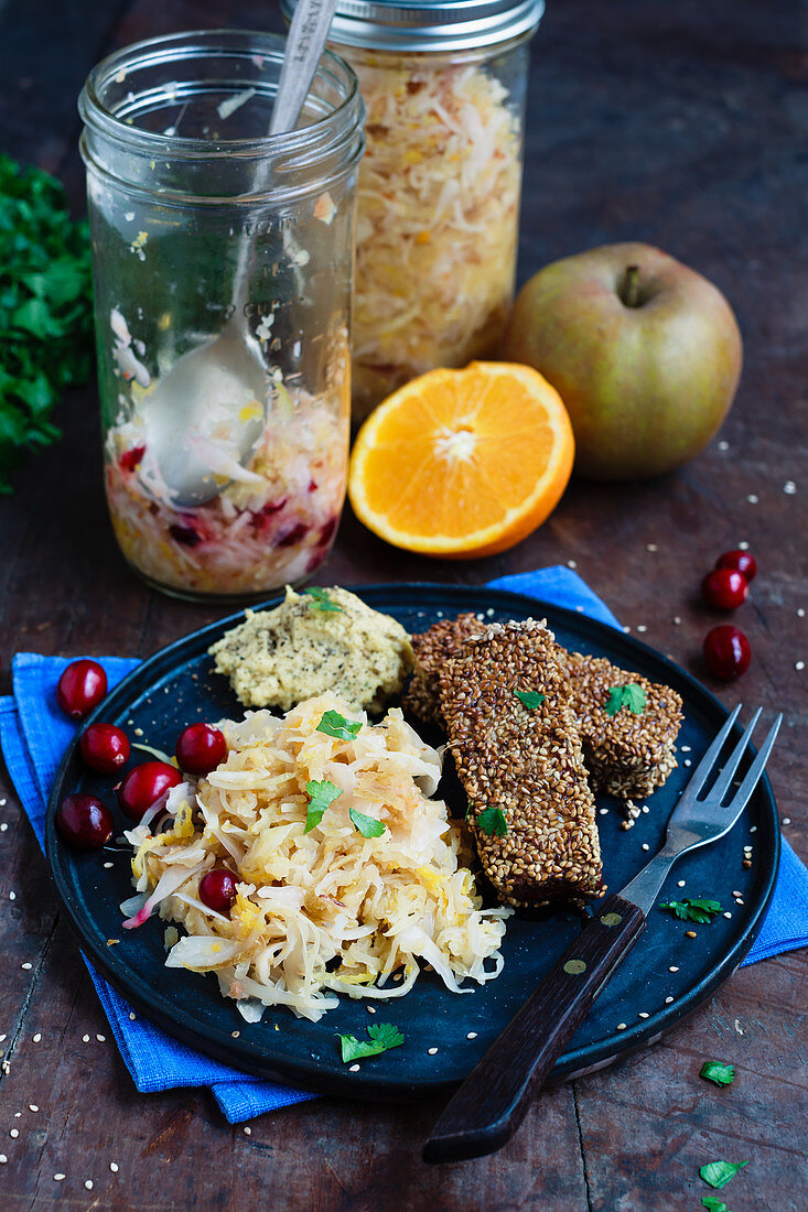 Orange, apple, and cranberry sauerkraut with spiced tofu coated in sesame seeds