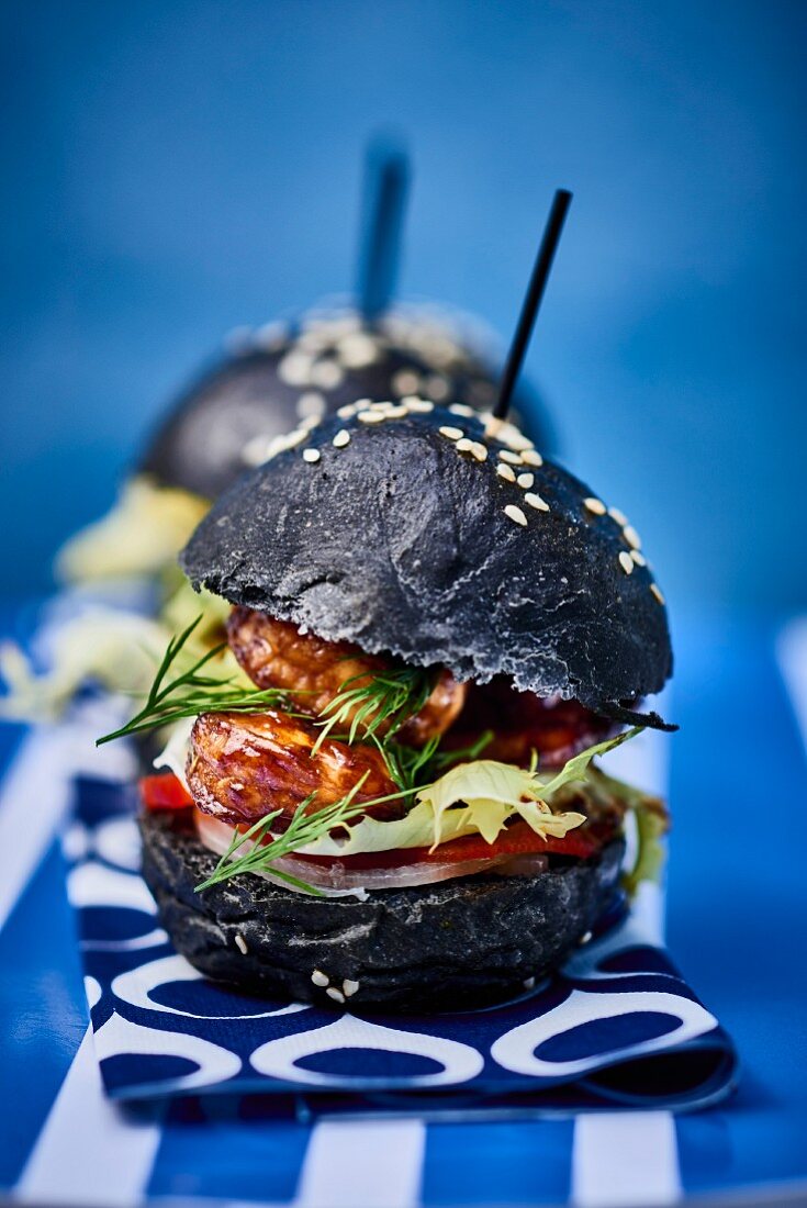A black burger with prawns