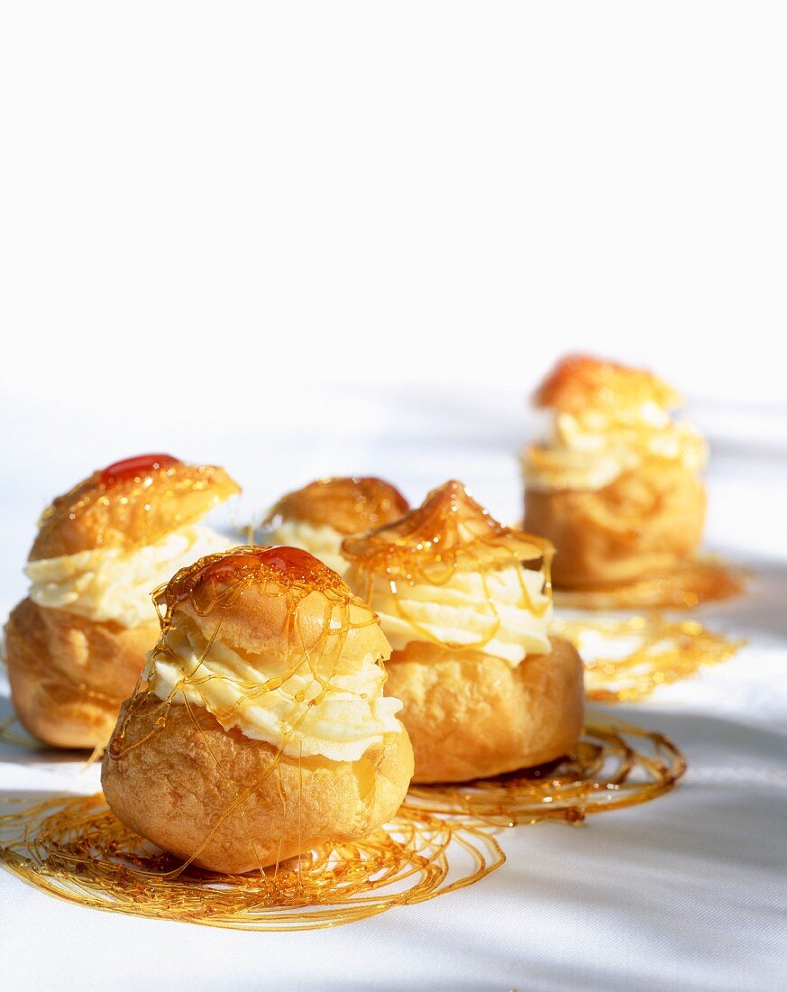 Profiteroles filled with cream and drizzled with caramel