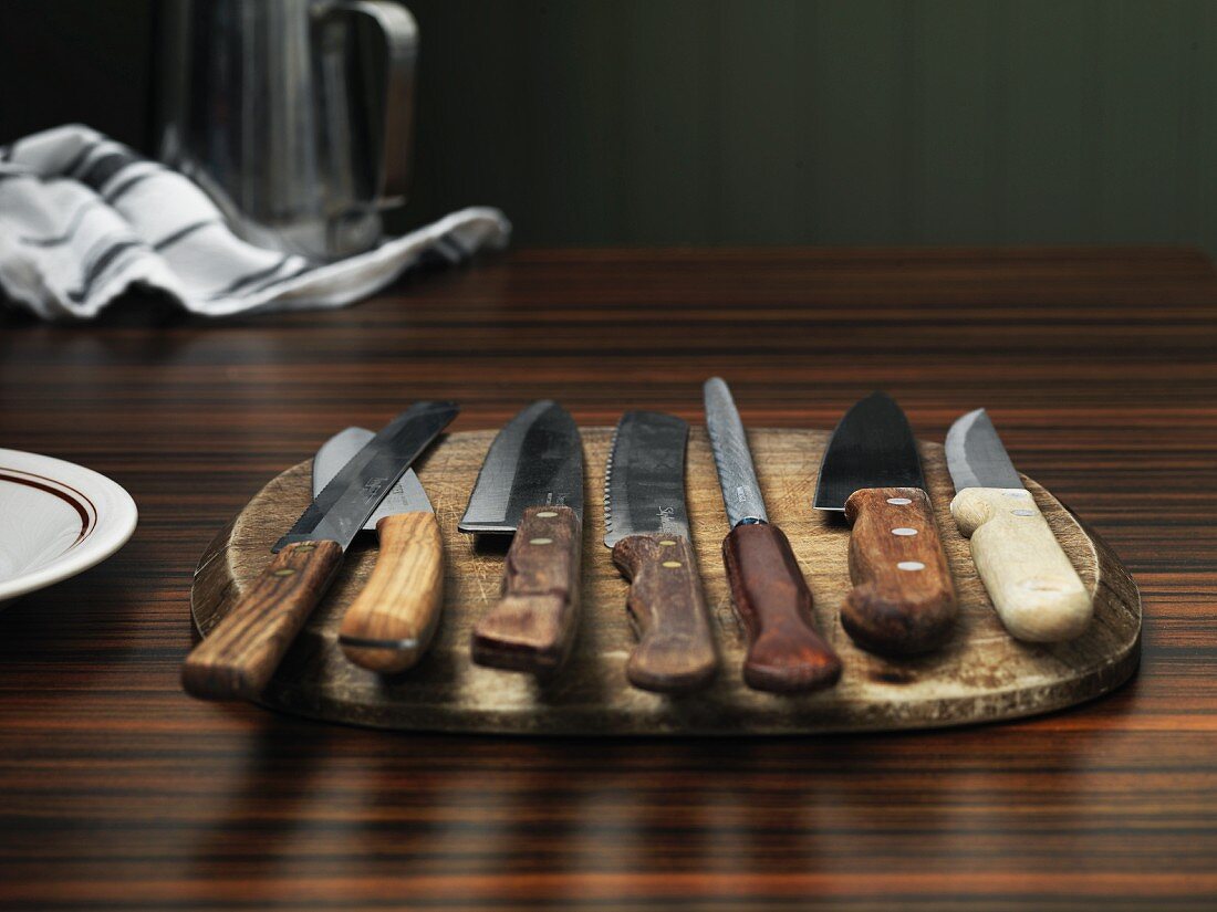 Various kitchen knives on a wooden board