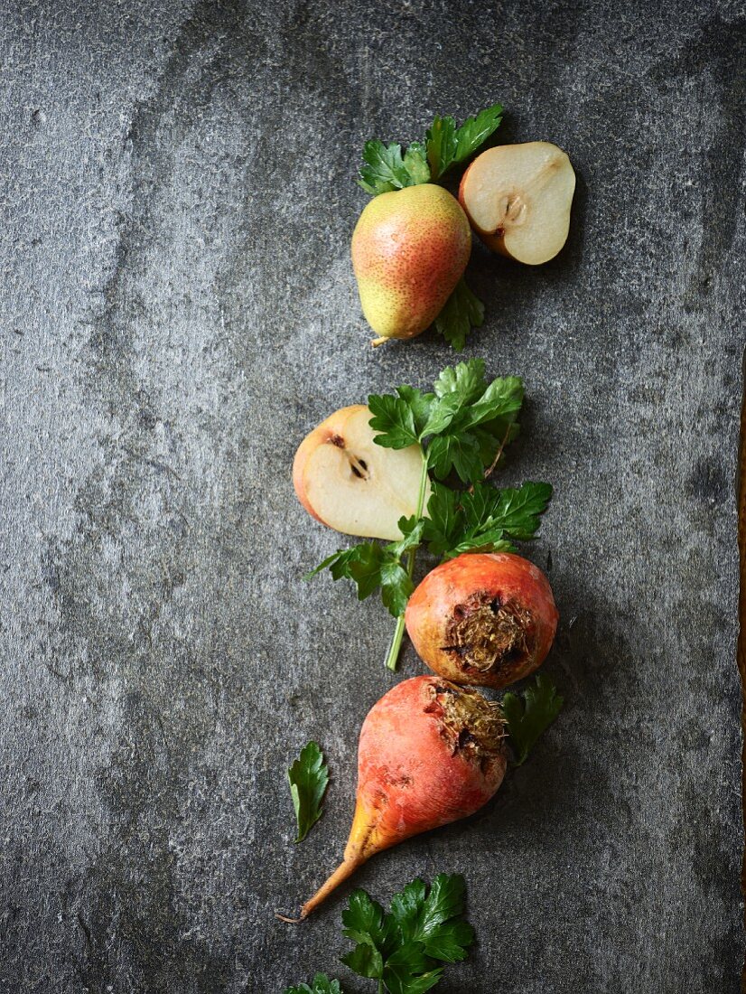 Pears, yellow beets, and parsley on a concrete background
