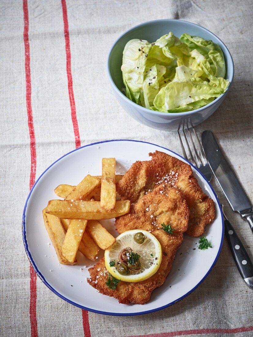 Sausage schnitzel with homemade French fries and lettuce