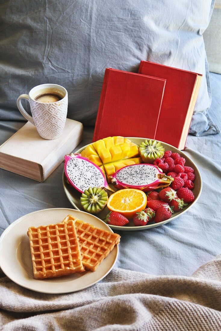 Frühstück im Bett mit belgischen Waffeln, frischem Obst und Kaffee