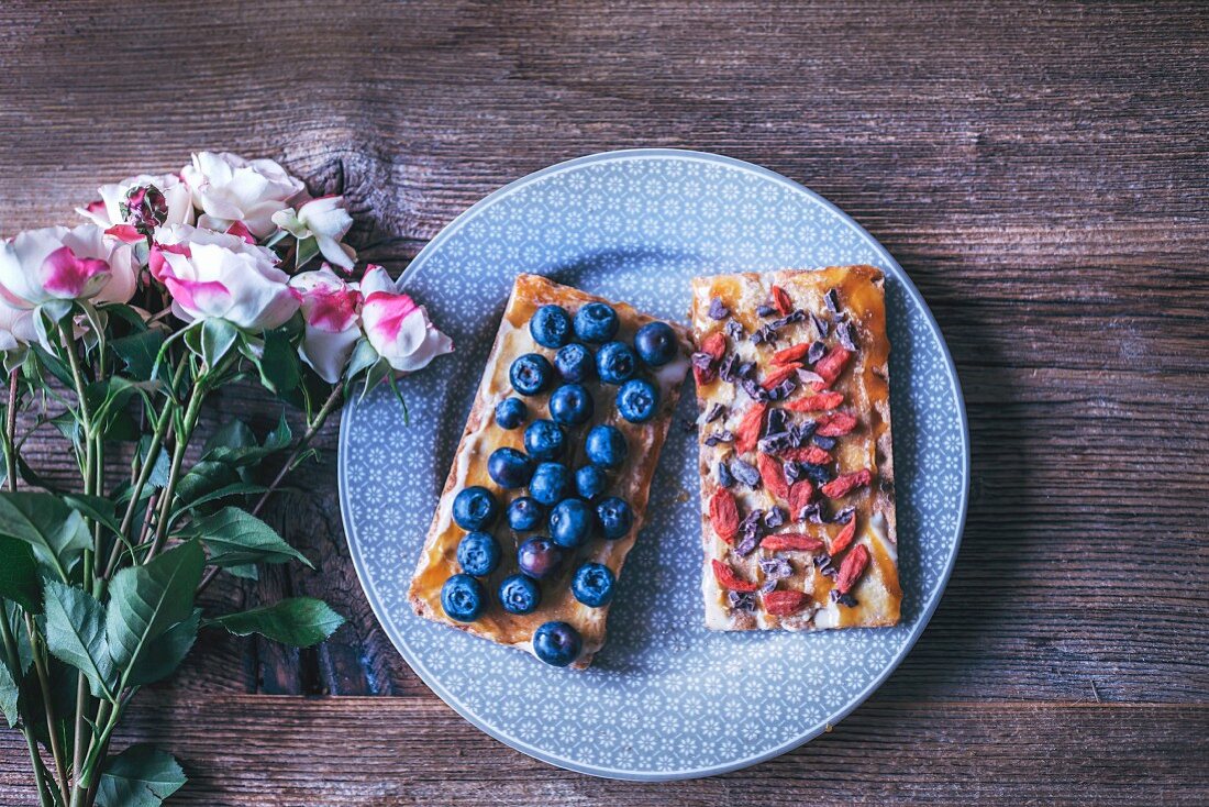 Crispy rye bread toasts with tahini, honey, blueberries, goji berries and cacao nibs