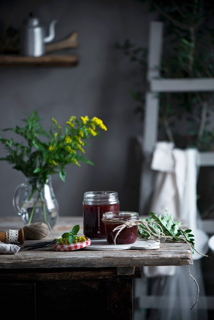 Hausgemachte Marmelade in Gläsern auf Holztisch in Landhausküche