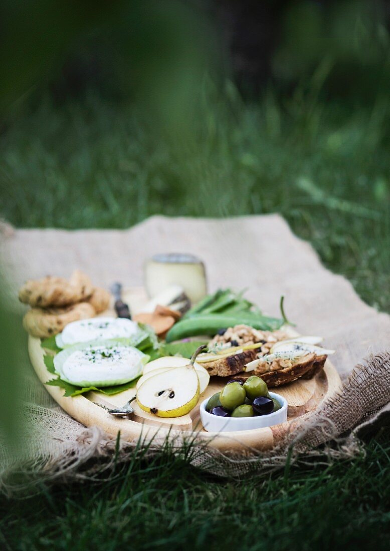 Picknick auf Holztablett und Leinentuch im Garten