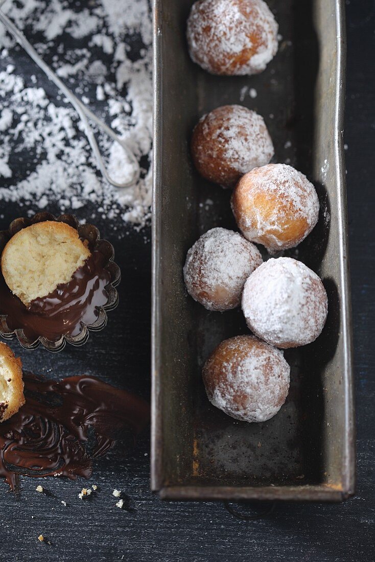 Castagnole (deep fried pastries, Italy) with icing sugar and melted chocolate