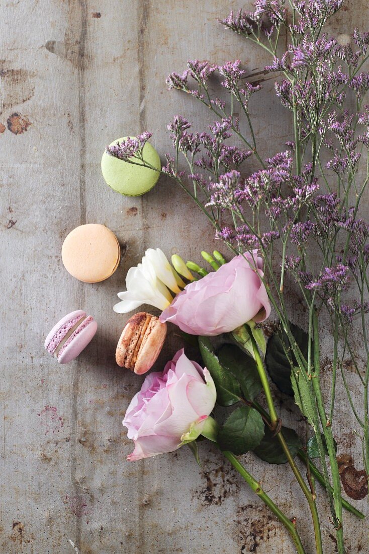 Verschiedene Macarons, daneben violett blühende Blumen