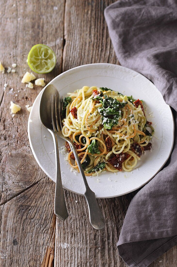 Spaghetti with mashed avocado, dried tomatoes, and kale