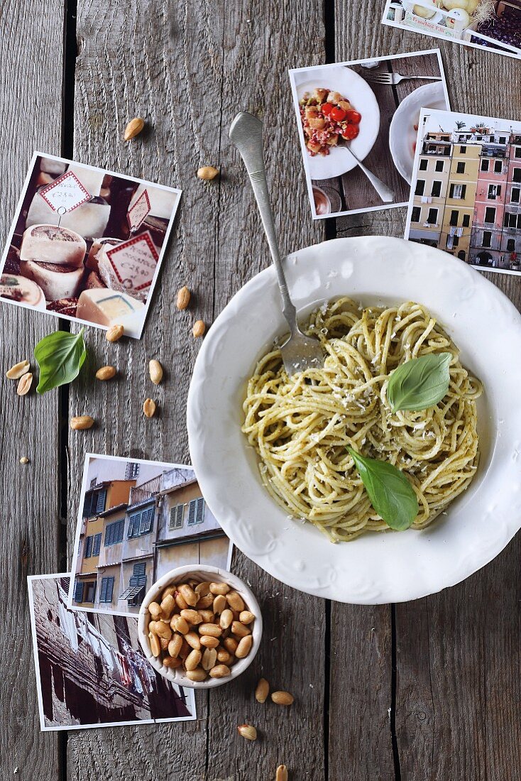 Spaghetti with pesto surrounded by holiday photos (Italy)