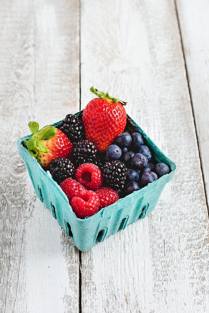 Different fresh berries in a cardboard box