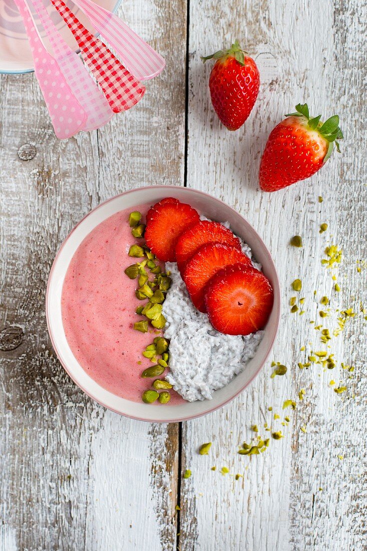 A strawberry smoothie bowl with coconut chia pudding and pistachios