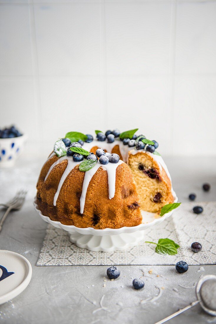 Sponge cake with blueberries and icing, sliced