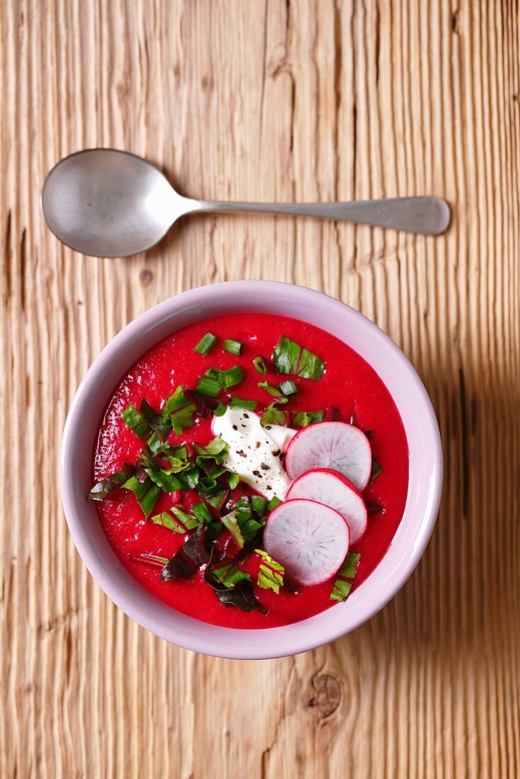 Rote-Bete-Suppe mit Rote-Bete-Blättern und Radieschenscheiben