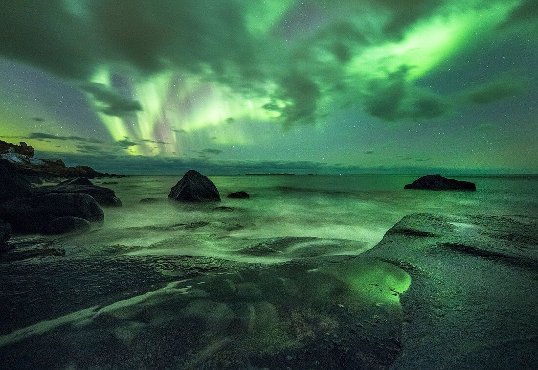 Aurora borealis over coastal rocks