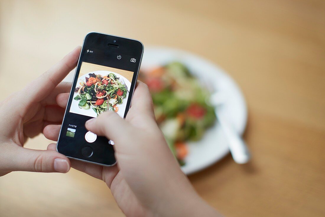 Woman taking photo of food with smartphone