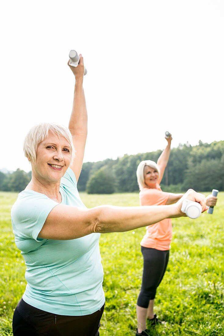 Two women exercising with hand weights