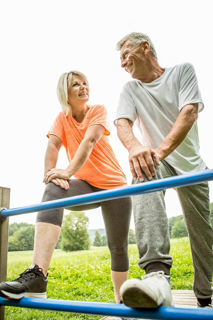 Couple smiling towards each other with legs on railings