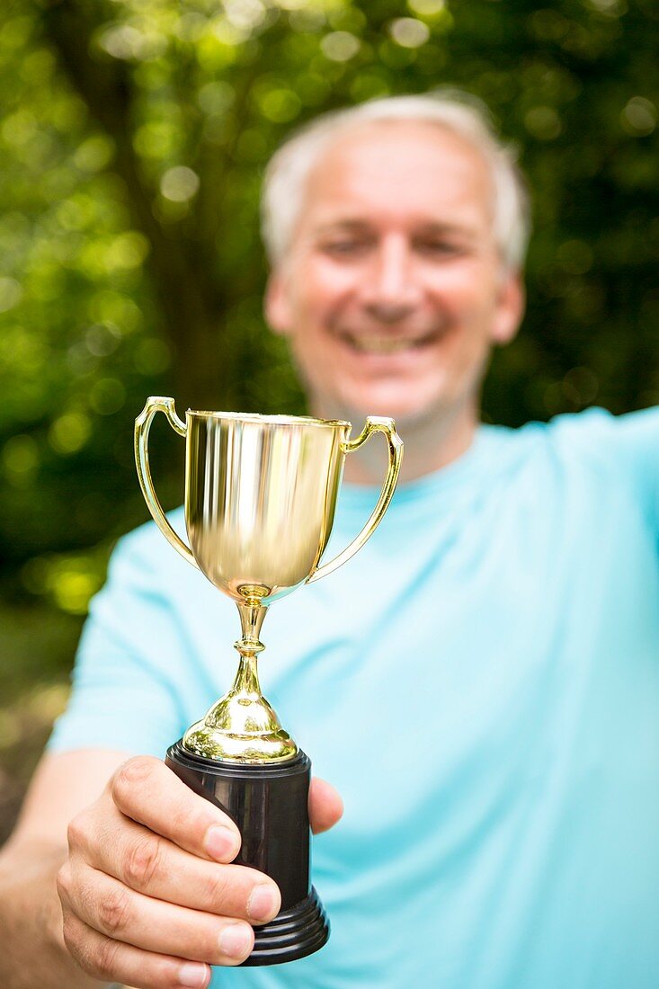 Mature man holding a trophy