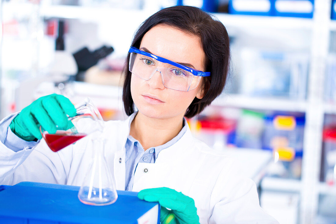 Scientist pouring sample into beaker