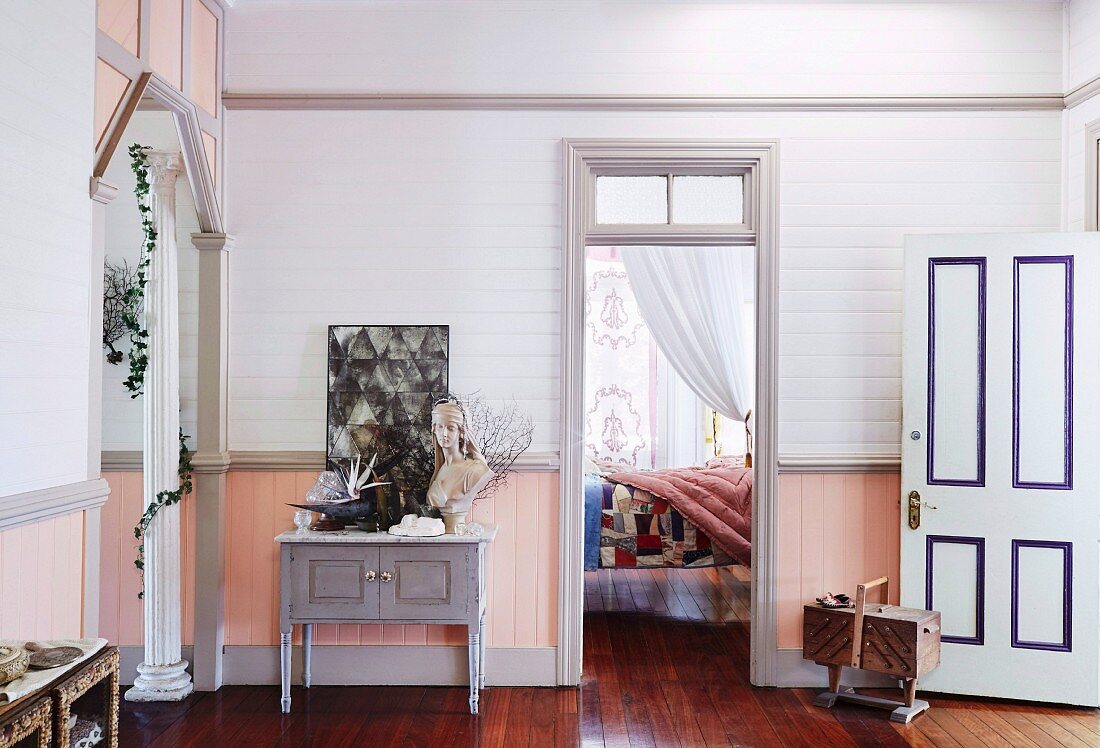 Hallway area with nostalgic flair and view of bedroom with patchwork blanket