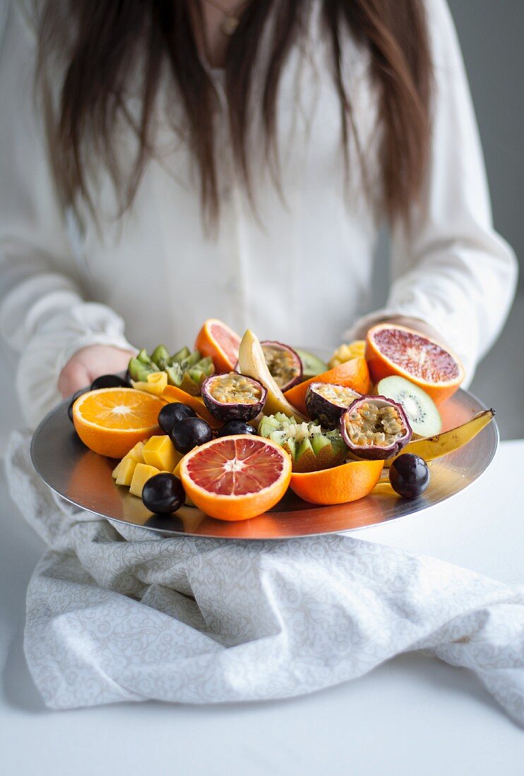 A woman serving a fruit platter