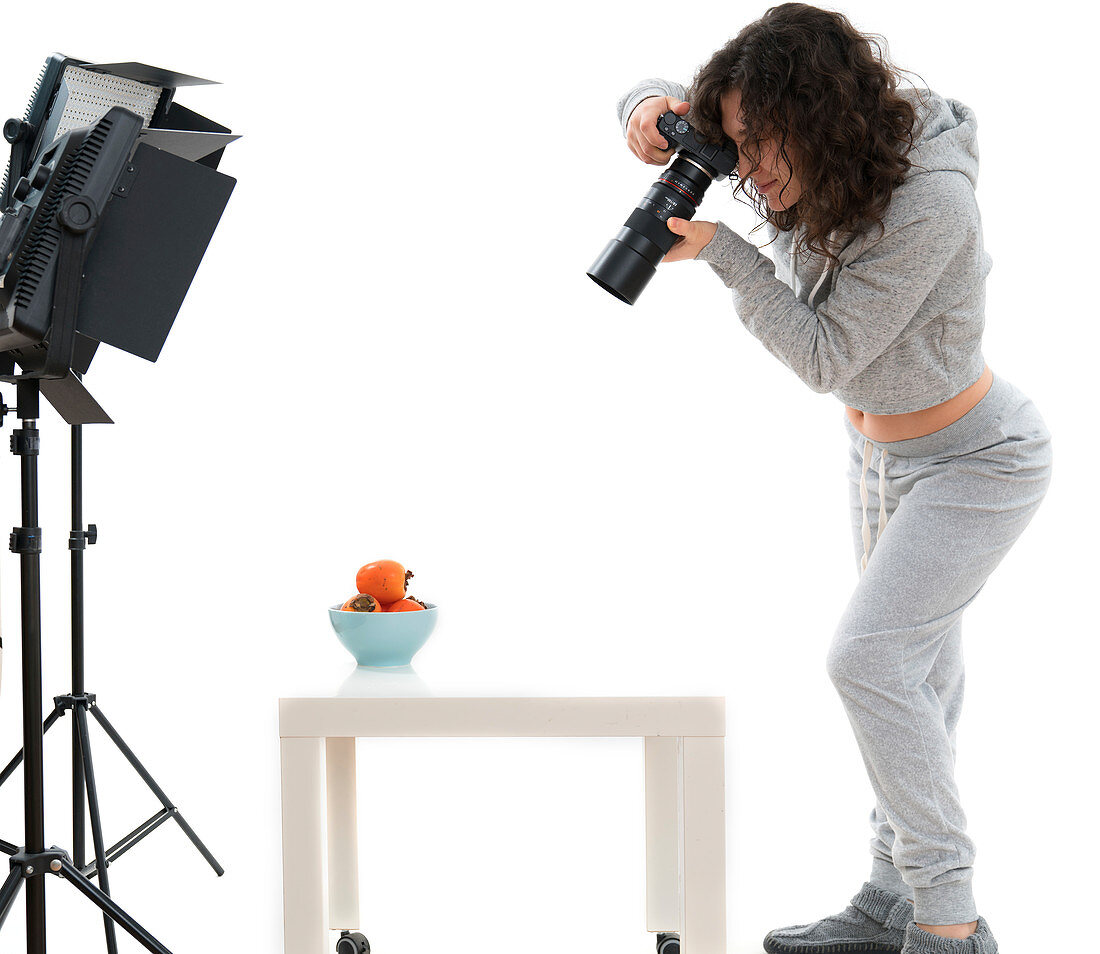 Female photographer in studio shooting still life