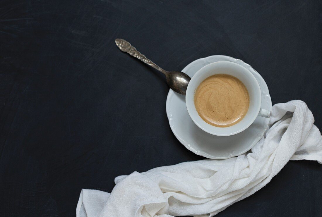 Eine Tasse Kaffee auf schwarzem Untergrund