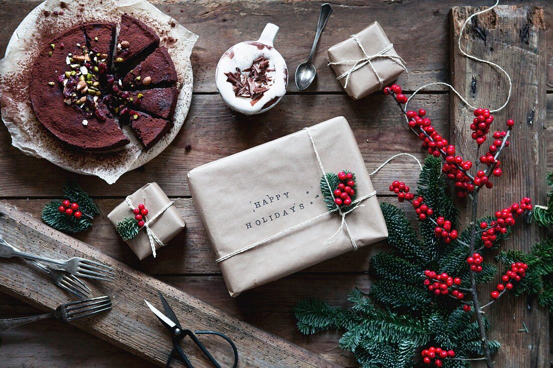 Schokoladenkuchen mit Kakao daneben Weihnachtsgeschenkpäckchen