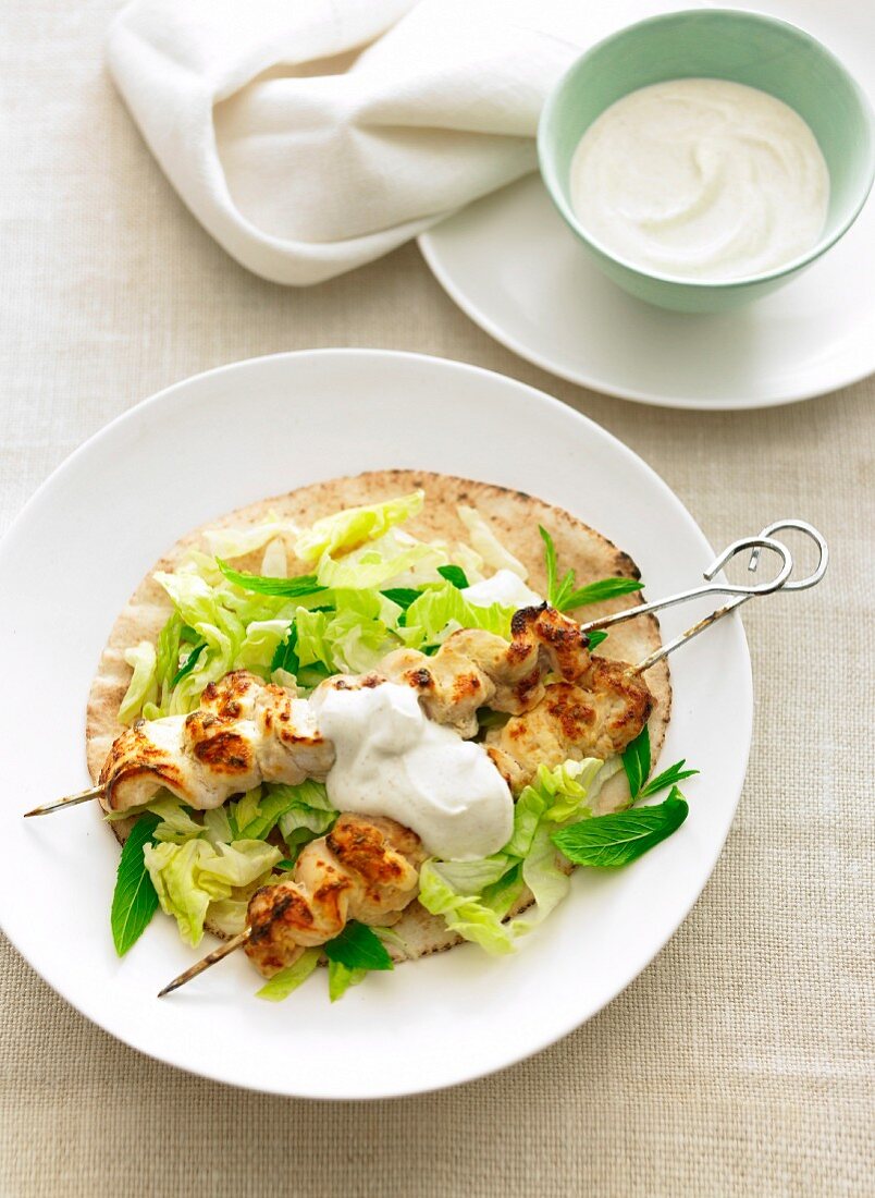 Gegrillte Hähnchenspiesse mit Joghurt und Eisbergsalat auf Pitabrot