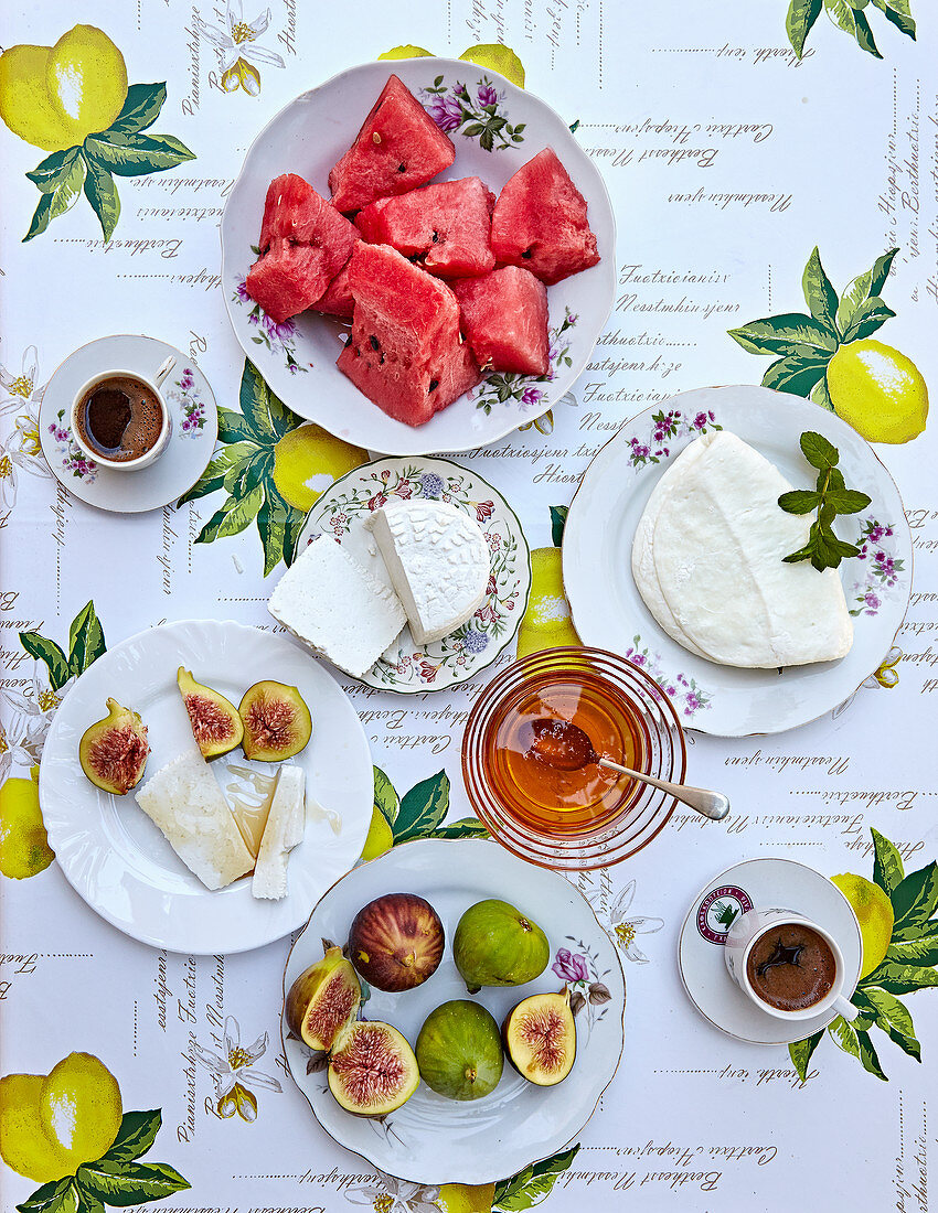 Sommerlicher Frühstückstisch mit Käse, Melone, Feigen und Kaffee (Aufsicht)