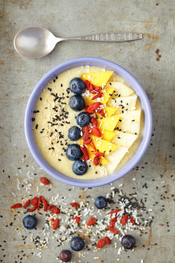 A tropical smoothie bowl with mango, pineapple, goji berries and coconut milk