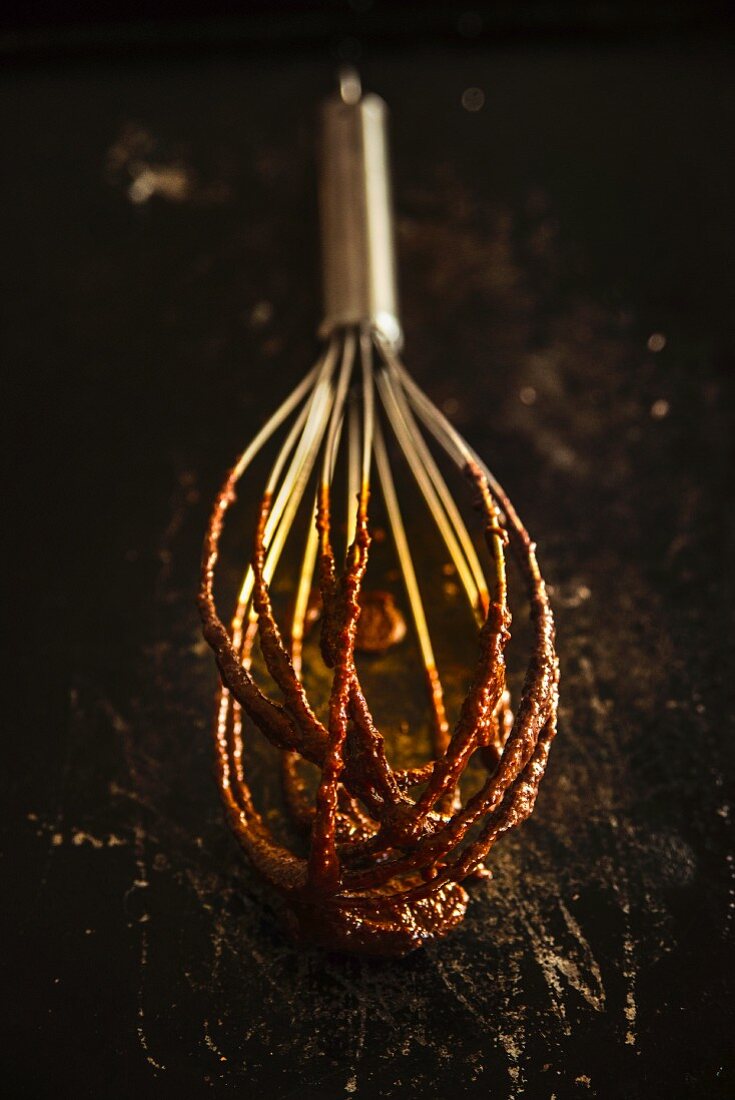 A whisk covered with chocolate cream