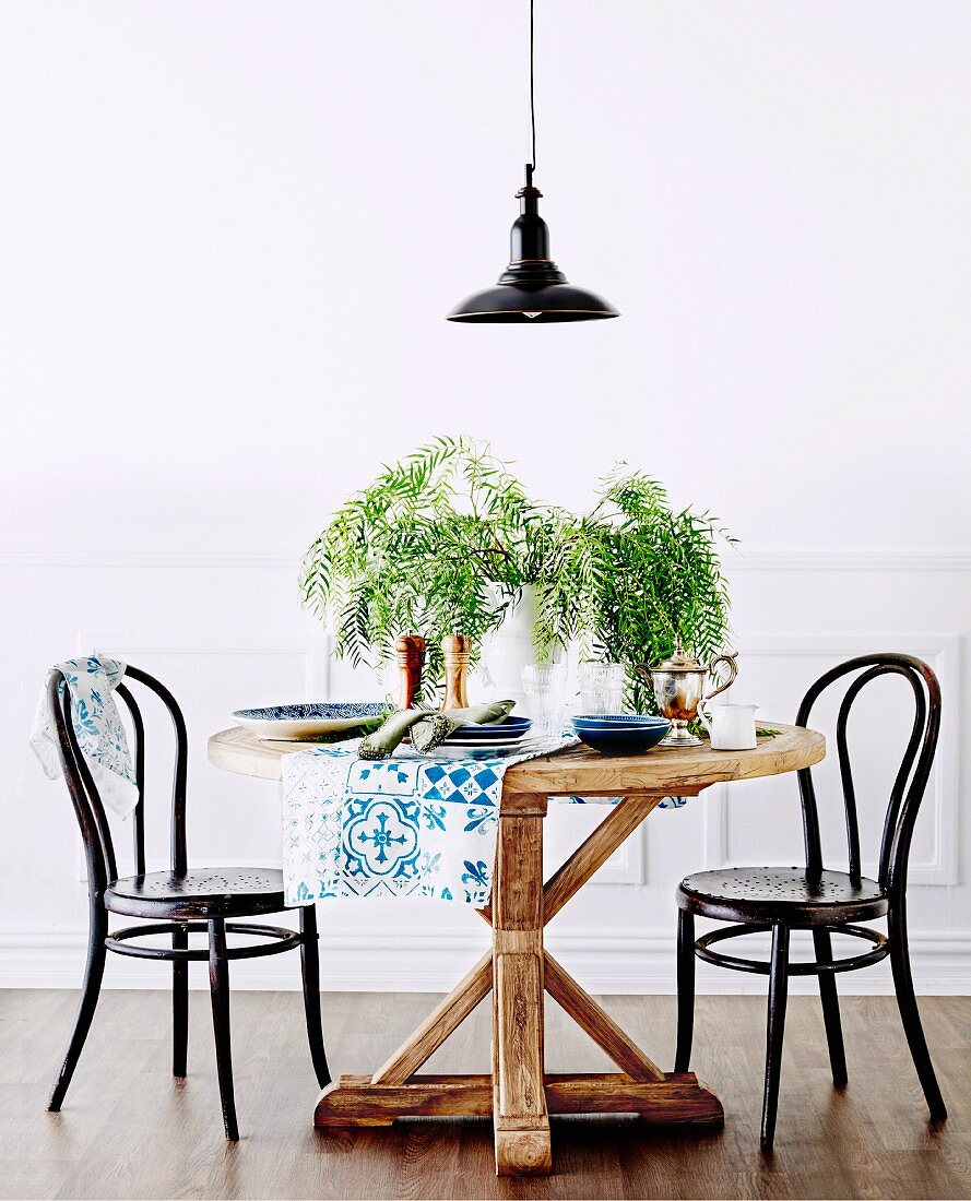 Round rustic table with black coffee house chairs