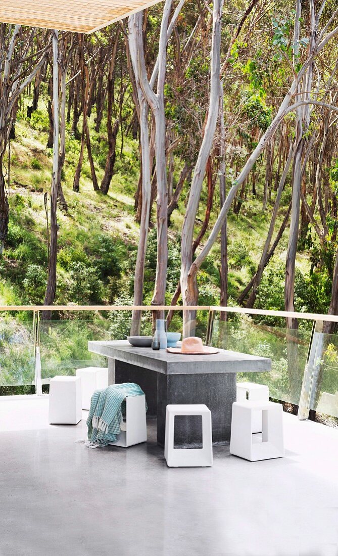 Minimalist balcony with screed, concrete table and view of the forest
