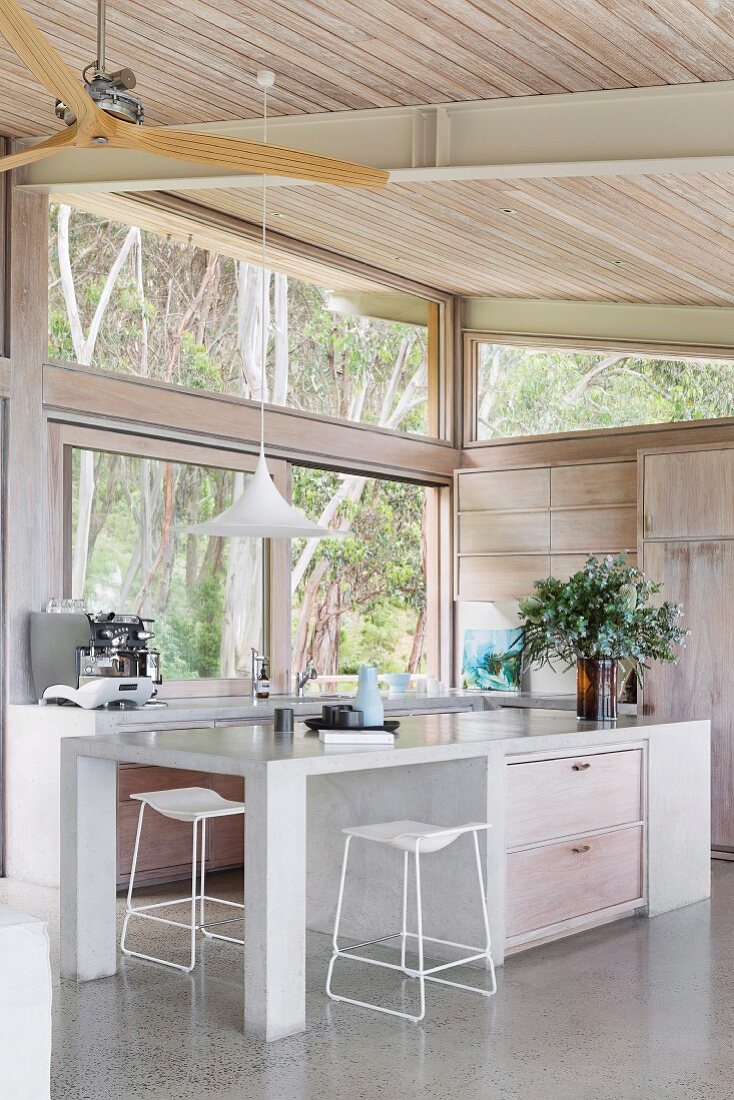 Moderne und minimalistische Küche mit Glasfront zum Wald